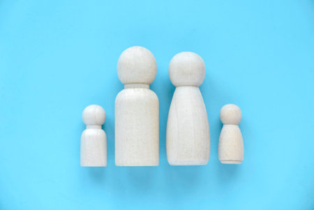 Happy family concept. Togetherness. Wooden peg represent parent and children over a blue background.の写真素材