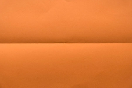 Folded orange color paper for background.の写真素材