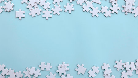 Scattered Jigsaw Puzzle Pieces on a Blue Background with Copy Space: Ideal for Creative Layouts and Designの写真素材
