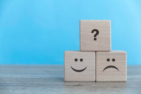 Exploring Emotions: The Journey from Happiness to Uncertainty in a Playful Wooden Cubeの写真素材