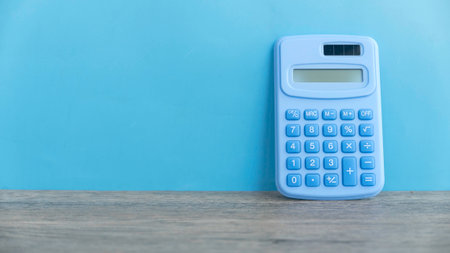 Calculator against a blue wall with copy space.の写真素材