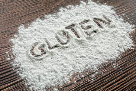 Gluten written on a sprinkled flour powder on the table.の写真素材