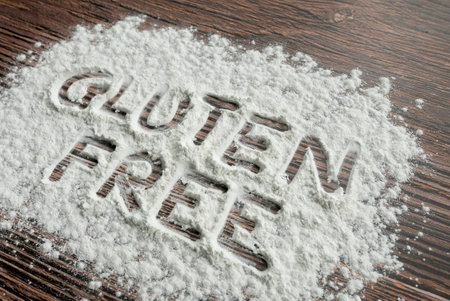Gluten free written on a sprinkled flour powder on the table.の写真素材