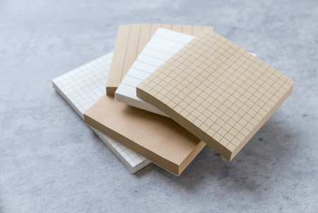 Variety of Paper Types: Lined, Grid, and Plain Sheets on a Gray Surface