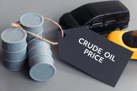 Crude Oil Price Concept with Oil Barrels and Toy Cars on Gray Backgroundの写真素材