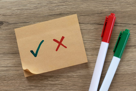 Checklist with Green Check Mark and Red Cross on Sticky Note with Pens.の写真素材