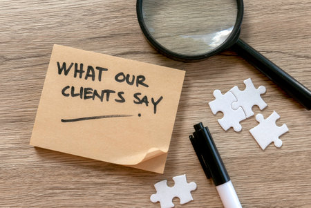 Client Testimonials Concept with Magnifying Glass, Puzzle Pieces, and Note on Wooden Deskの写真素材