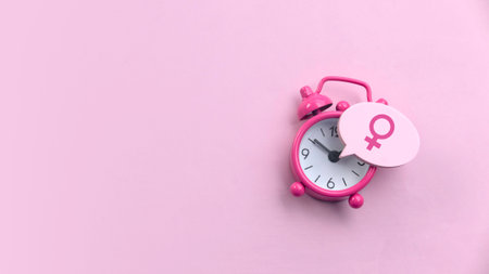 Menopause concept. Women symbol over a watch. Healthcare and medical for women. Pink background with copy space.の写真素材