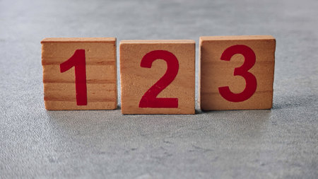Wooden Number Blocks 1, 2, 3 Arranged on Gray Surfaceの写真素材