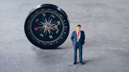 Miniature businessman and a compass