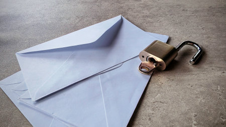An open envelope and open metallic padlock. Email security concept.の写真素材
