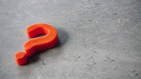 Orange question mark symbol on gray surface.の写真素材
