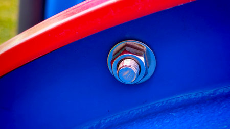 Close-Up of a Bolt and Nut Assembly with Red and Blue Contrasting Elementsの写真素材