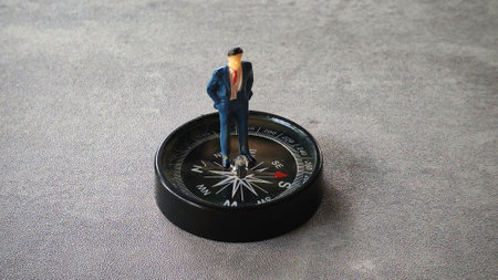 Miniature businessman on a compass