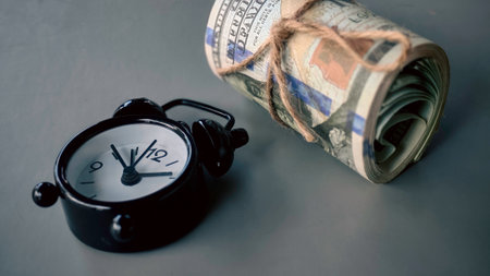 Alarm Clock with USD Money Representing Time and Financial Valueの写真素材