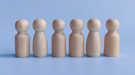 A Row of Wooden Figures Representing Different Genders Standing Over a Blue Background Symbolizing...