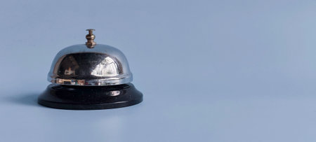 Classic Service Bell on Blue Background with Copy Space Representing Customer Service, Hospitality, and Attentionの写真素材