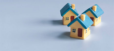 House Model Isolated on Blue Background with Copy Space Representing Real Estate, Home Ownership, and Property Investmentの写真素材