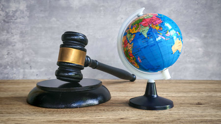 Gavel and Globe on Wooden Table, Symbolizing International Law, Global Justice, and World Governanceの写真素材