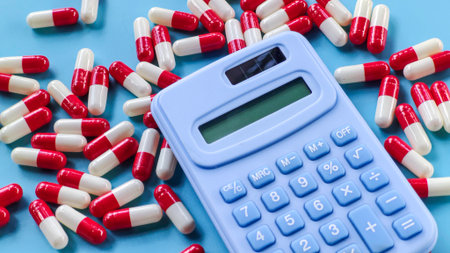 Calculator and Red and White Capsules on Blue Backgroundの写真素材