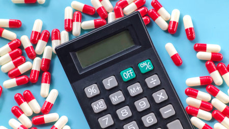 Calculator and Red and White Capsules on Blue Backgroundの写真素材