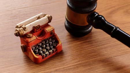 Miniature Vintage Typewriter and Gavel on Wooden Tableの写真素材