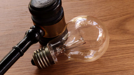 Gavel and Light Bulb on Wooden Tableの写真素材