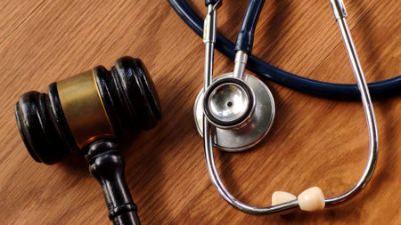 Gavel and Stethoscope on Wooden Tableの写真素材