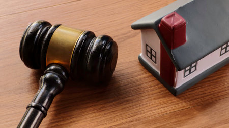Gavel and Miniature House on Wooden Tableの写真素材
