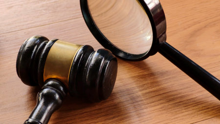 Gavel and Magnifying Glass on Wooden Tableの写真素材