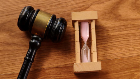 Gavel and Hourglass on Wooden Tableの写真素材