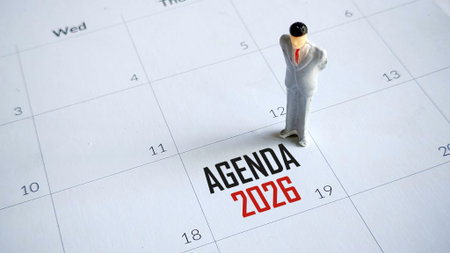 Businessman Miniature Standing on a Calendar with Agenda 2026 Text