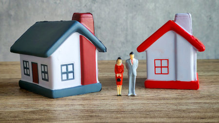 Empty Miniature House Model on a White Table Against a Grey Background