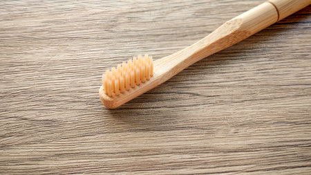 Close-Up of a Natural Bamboo Toothbrush on a Wooden Table Surface