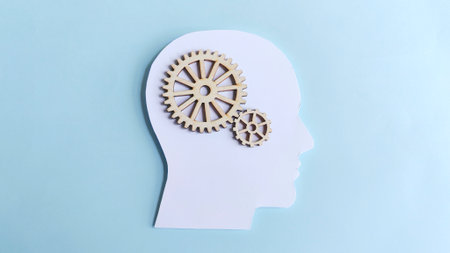Human head silhouette with interconnected wooden gears inside, symbolizing mechanics of the mind, logical thinking, innovation, and strategic process.の写真素材