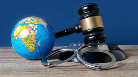 Miniature World Globe, Handcuffs, and Gavel Symbolizing International Law and Global Justiceの写真素材