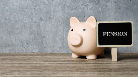 Personal Pension Savings concept with a piggy bank next to a small chalkboard sign reading PENSION, illustrating retirement financial security and long-term planning.の写真素材