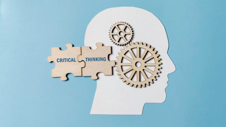Critical Thinking process illustrated by interlocking puzzle pieces and wooden gears inside a human head silhouette, representing problem-solving and mental activity.の写真素材