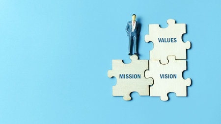 Corporate Leadership standing on the foundation of Mission, Vision, and Values, represented by jigsaw puzzle pieces for strategic alignment and business success.の写真素材