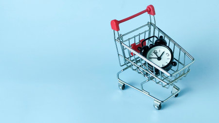 Time-Sensitive E-commerce and Limited Time Offer Concept: Alarm Clock in a Miniature Shopping Cartの写真素材