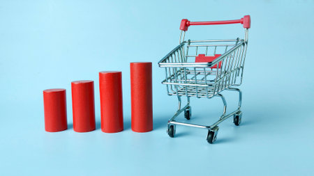Rising Consumer Costs and Retail Inflation Concept: Shopping Cart Next to an Increasing Red Bar...