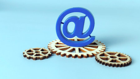 Blue At Symbol Resting on Wooden Gears Representing Email System Mechanics, Digital Processes, and Internet Infrastructureの写真素材