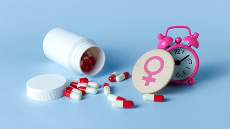 Women's Health, Hormone, and Menstrual Cycle Timing Concept: Female Symbol, Alarm Clock, and Medicineの写真素材