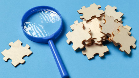 Finding the Missing Piece: Magnifying Glass Analyzing Jigsaw Puzzle Partsの写真素材