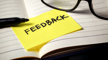 Importance of Constructive Feedback: Yellow Reminder Note on Open Notebook