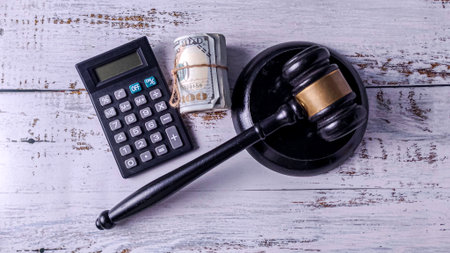 Gavel, Calculator, and US Dollar Bills on a Desk: Legal Fees, Financial Crime, and Judicial Cost Analysisの写真素材