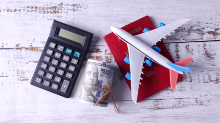 Calculator, Money, Passport, and Airplane: Calculating Travel Budget, Vacation Costs, and International Financeの写真素材