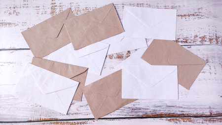 Correspondence Chaos: Scattered White and Brown Envelopes on a Rustic Wooden Tableの写真素材