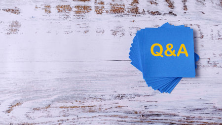 Questions and Answers: Stack of Blue Notes with Q&A Text on Wooden Backgroundの写真素材