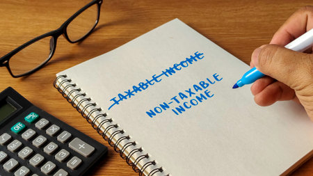 Hand writing Non-Taxable Income with Taxable Income crossed out on a notebook next to a calculator...